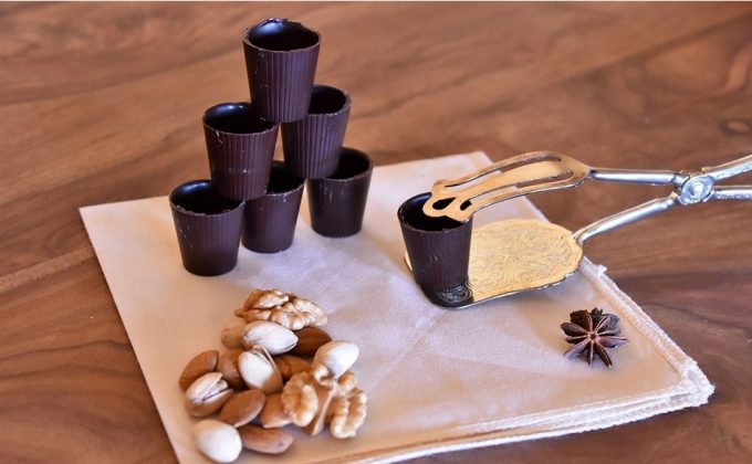 Bicchierini di cioccolato fondente dolci aveja distesi su un panno pianco pronti per la colazione